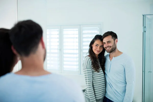 Casal olhando no espelho do banheiro juntos — Fotografia de Stock