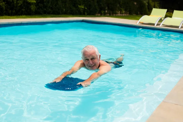 Senior schwimmt im Pool — Stockfoto