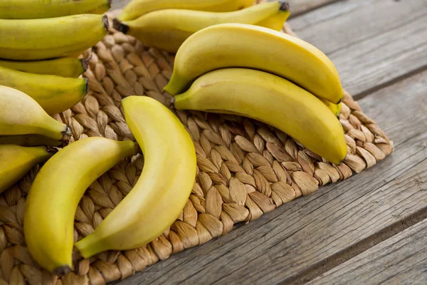 Bananas kept on placemat on wooden table — Stock Photo, Image