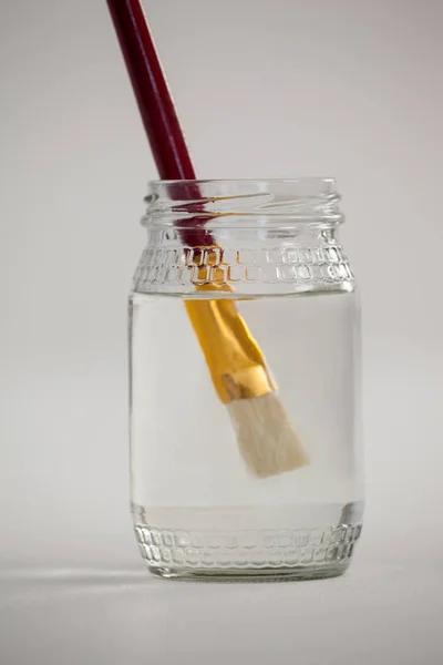 Pincel de pintura em um frasco cheio de água — Fotografia de Stock