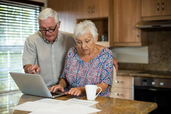 Seniorin benutzt Laptop in der Küche — Stockfoto