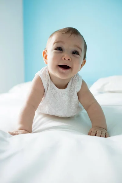 かわいい女の笑みを浮かべて赤ちゃんのベッドの上 — ストック写真