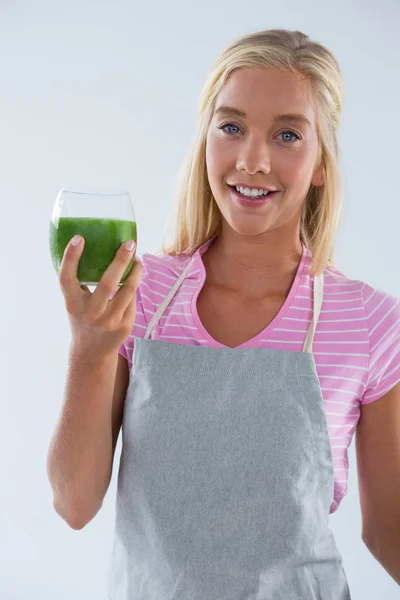 Portrait of woman holding a glass of vegetable smoothie — Stock Photo, Image