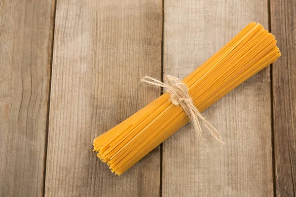 Bundle of raw spaghetti tied with rope — Stock Photo, Image