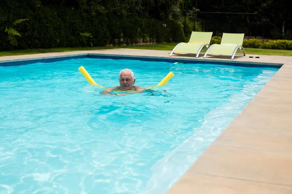 Senior man swimming with inflatable tube — Stock Photo, Image