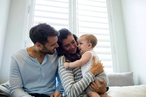 Casal segurando sua menina no quarto — Fotografia de Stock