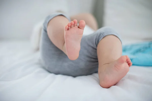 Detail baby girl stopy relaxační na posteli — Stock fotografie