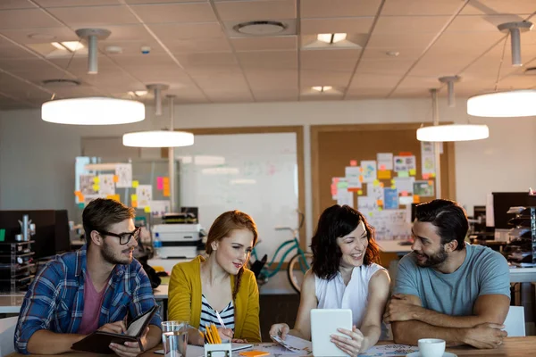 Kreatives Business-Team diskutiert über digitales Tablet am Schreibtisch — Stockfoto