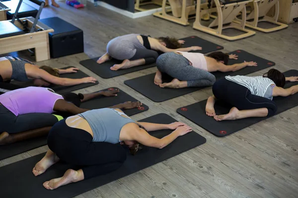 Donne che eseguono esercizio di stretching sul tappeto esercizio — Foto Stock