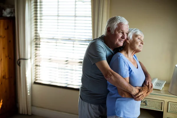 Äldre par omfamnar varandra i sovrummet — Stockfoto