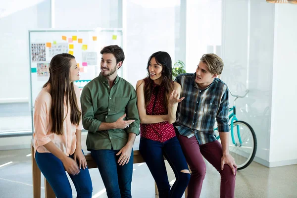 Smiling creative business team interacting with each other — Stock Photo, Image