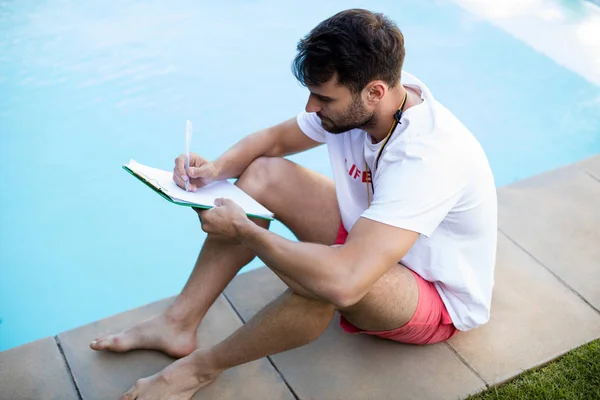 Badmeester schrijven op Klembord bij zwembad — Stockfoto