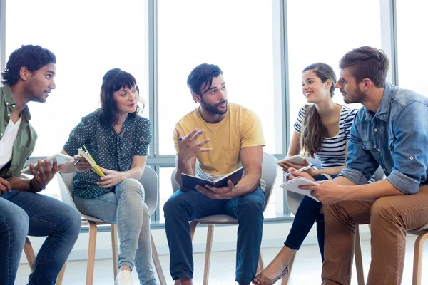 Equipo creativo de negocios discutiendo con sus diarios —  Fotos de Stock