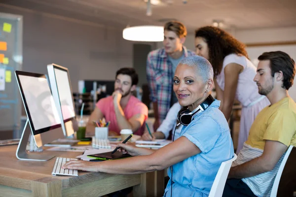 Donna che lavora su PC desktop con il suo team — Foto Stock