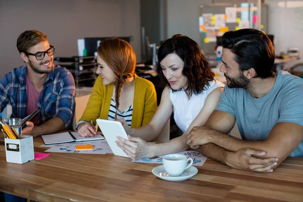 Equipe de negócios criativa discutindo sobre tablet digital na mesa no escritório — Fotografia de Stock