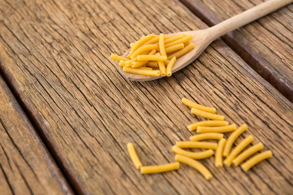 Macarrão macarrão na superfície de madeira — Fotografia de Stock