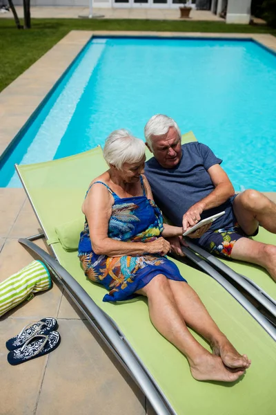 Senior paar met behulp van digitale tablet op lounge stoel — Stockfoto