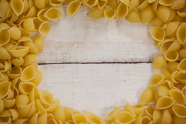 Massa de conchiglie na mesa de madeira — Fotografia de Stock