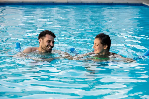 Young couple swimming with inflatable tubes — Stock Photo, Image