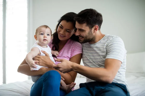 Couple playing with their baby girl on bed — Stock Photo, Image
