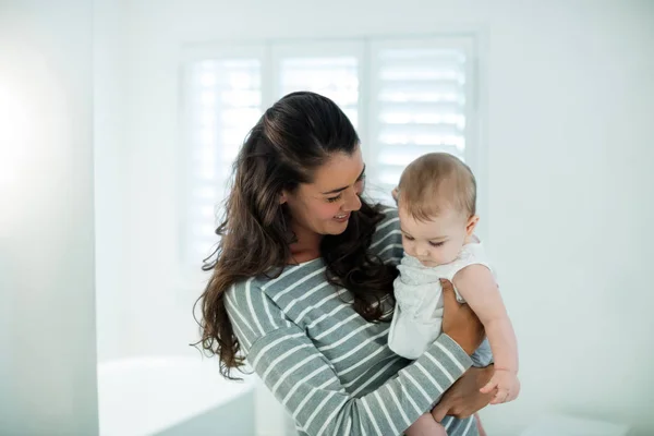 Mère tenant sa petite fille dans la salle de bain — Photo