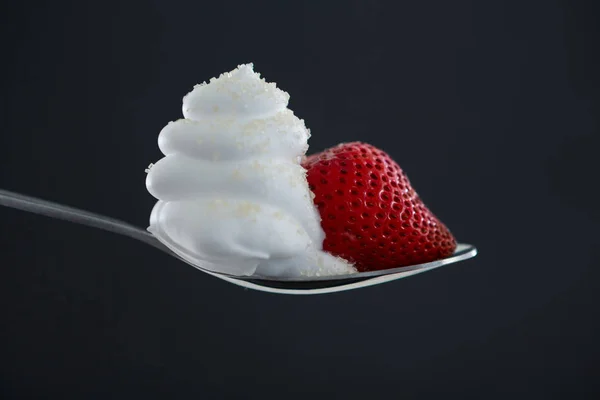 Close-up of fresh strawberry with cream in spoon — Stock Photo, Image