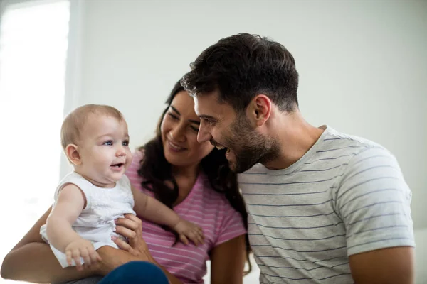 Padres jugando con su bebé en el dormitorio — Foto de Stock