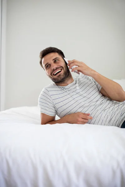 Ο άνθρωπος μιλάει στο κινητό τηλέφωνο στο υπνοδωμάτιο — Φωτογραφία Αρχείου