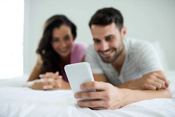 Casal usando telefone celular no quarto — Fotografia de Stock