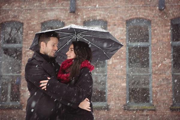 Couple embrassant pendant les chutes de neige — Photo