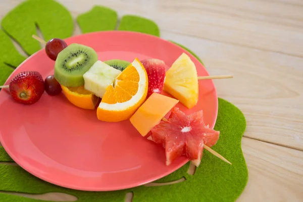 Primer plano de brochetas de fruta en plato —  Fotos de Stock