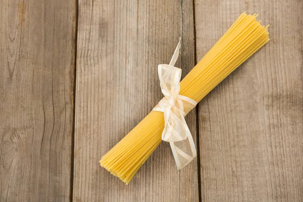 Paquete de espaguetis crudos atados con cinta blanca — Foto de Stock
