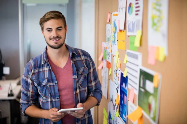 Man using digital tablet next to the board with sticky notes — Stock Photo, Image