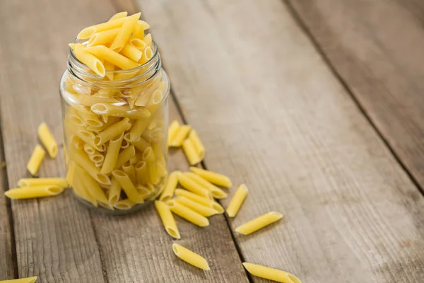 Glazen pot gevuld met pinnate pasta — Stockfoto