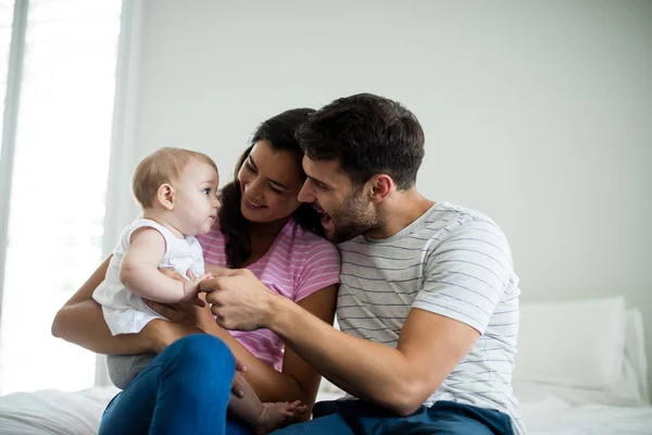 Pareja jugando con su bebé en el dormitorio —  Fotos de Stock