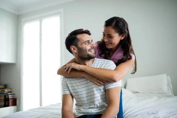 Pareja abrazándose en el dormitorio — Foto de Stock