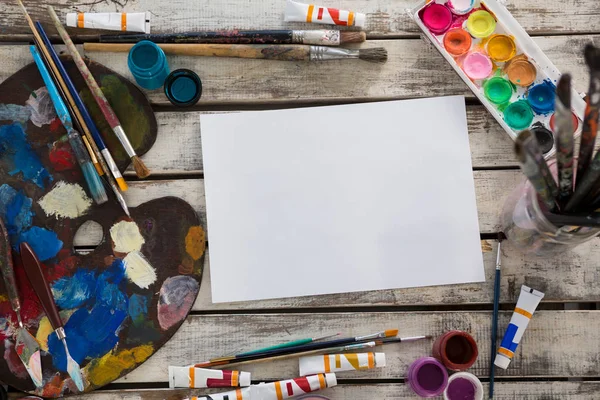 Pinturas de acuarela, papel, paleta y pinceles sobre superficie de madera — Foto de Stock