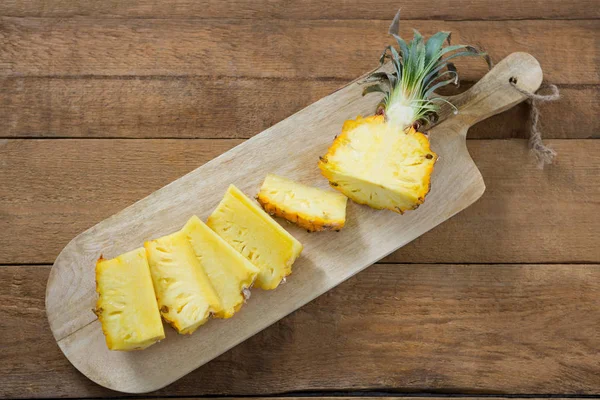 Plastry i połowę ananas trzymane na deska do krojenia — Zdjęcie stockowe