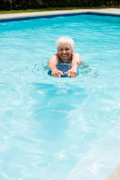 Äldre kvinna bada i poolen — Stockfoto