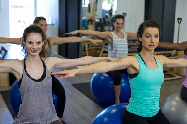 Mulheres sorridentes se exercitando com bola de fitness — Fotografia de Stock
