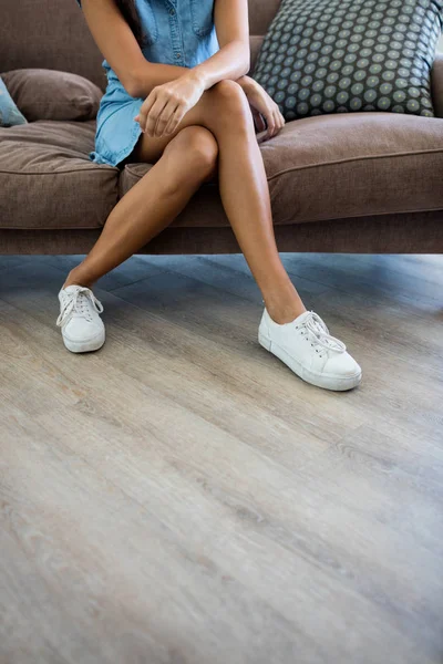 Sección baja de la mujer relajándose en el sofá en la sala de estar —  Fotos de Stock