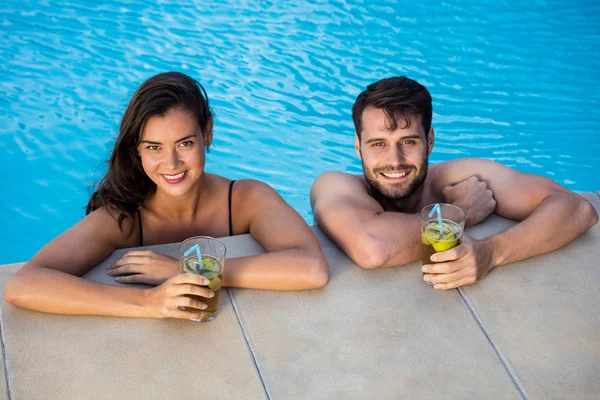 Retrato de jovem casal relaxante na piscina — Fotografia de Stock