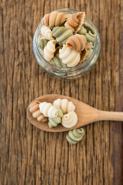 Tarro de vidrio y cuchara llena de pasta —  Fotos de Stock