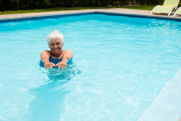 Mujer mayor nadando en la piscina — Foto de Stock