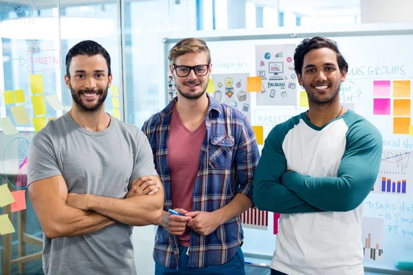 Creative business team stående mot väggen med fästisar — Stockfoto