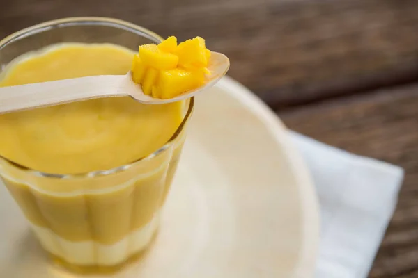Φρέσκο ποτήρι smoothie διατηρούνται σε πιάτο με ανανά σε κουτάλι — Φωτογραφία Αρχείου