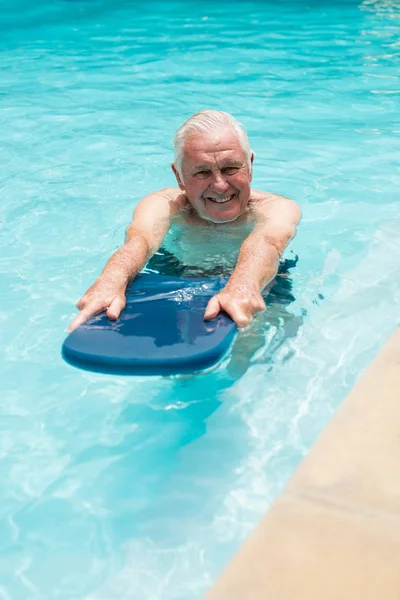 Старший мужчина плавает в бассейне — стоковое фото