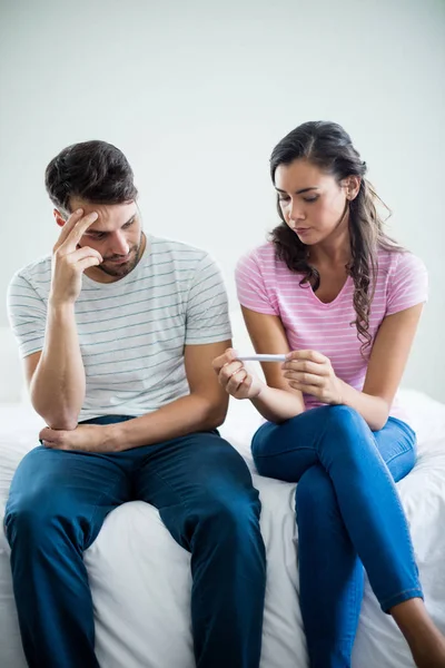 Bezorgd paar resultaten van een zwangerschapstest uitzoeken in slaapkamer — Stockfoto