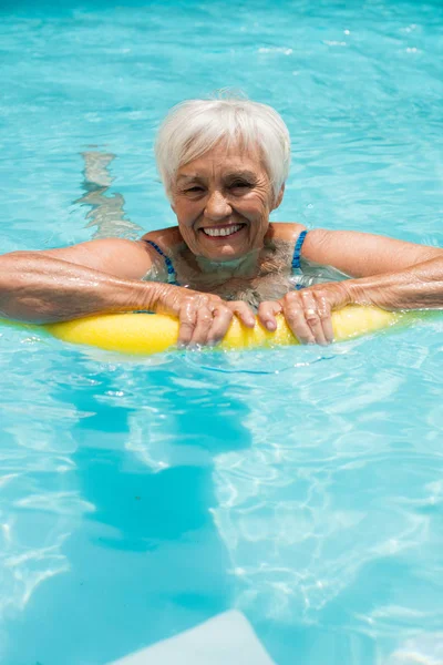 Senior vrouw zwemmen met opblaasbare buis — Stockfoto