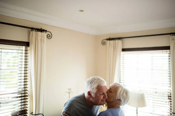 Pareja mayor abrazándose en el dormitorio — Foto de Stock